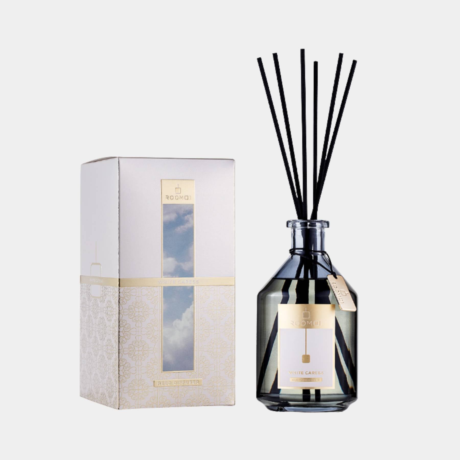 Roomoi White Caress 500ml reed diffuser with stick, bottle and box. Front view 